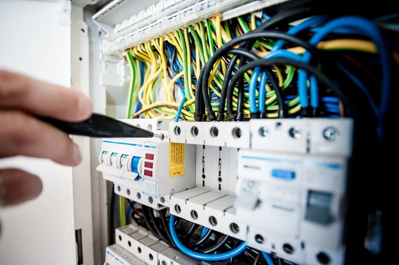Electrician testing circuit breakers inside an electrical panel before any parts are replaced